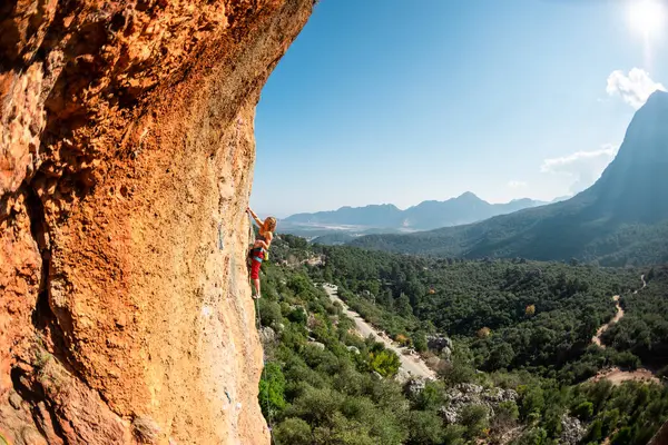 The girl climbs the rock. Climber trains on natural terrain. Extreme sport. Lessons on the street. A woman overcomes a difficult climbing route in Turkey. sports and adventure.