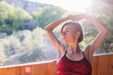 Yakın plan. Yogadan sonra kısa saçlı ve boynunda mücevherlerle çekici bir genç kızın portresi. Sokakta yoga dersleri. sağlık ve güç kavramı.