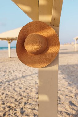 Kırık bir şapka sahildeki bir direkte asılı duruyor. Kumsalda dinlenmek..