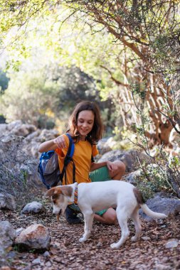 boy rests while trekking and plays with a dog