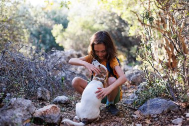 boy rests while trekking and plays with a dog