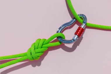 two ropes with secure knots are connected by a carabiner. Equipment for rock climbing and mountaineering. reliable connection. Safety rope. concept of reliability and strength.