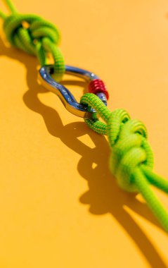 two ropes with secure knots are connected by a carabiner. Equipment for rock climbing and mountaineering. reliable connection. Safety rope. concept of reliability and strength.