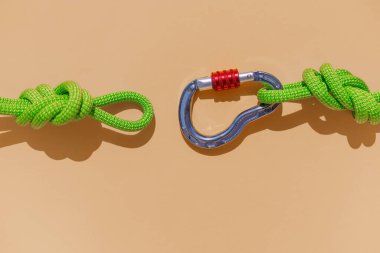 two ropes with secure knots are connected by a carabiner. Equipment for rock climbing and mountaineering. reliable connection. Safety rope. concept of reliability and strength.