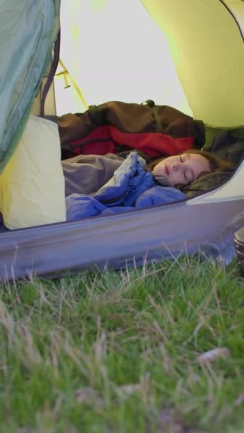 子供はテントで寝ている 子供たちとキャンプやトレッキング 子供はテントで目覚め 笑顔になる 少年は寝袋で寝ている 子供と一緒に山でハイキング アクティブライフスタイル — ストック動画