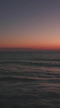 Yaz akşamından sonra deniz sahilinde yeni bir ay doğuyor. Güzel manzara.