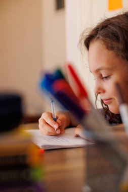 Çocuk sınıfta bir deftere yazıyor. Okuldaki çocuk..