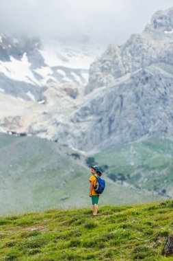 Gezgin çocuk. Sırt çantalı bir turist dağ yolunda yürüyor. Yürüyüş ve aktif sağlıklı yaşam tarzı. çocuklarla macera tatili.