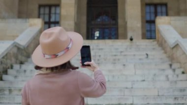Genç bir kadın eski kasabayı gezerken telefonuyla şehrin güzel manzarasının fotoğraflarını çekiyor. seyahat ve tatil.