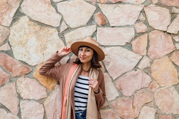 stock image Young beautiful smiling girl in fashionable clothes and hat. Sexy carefree woman posing on the street. Positive brunette model outdoors. Cheerful and happy. Near the wall.