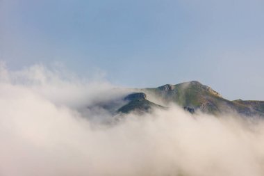 Karla kaplı dağların üzerinde bulutlar. Dağların ve sıradağların manzarası. Dağlarda kar