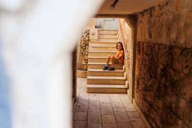 Çocuk eski bir evin merdivenlerinde oturuyor. seyahat ve macera.