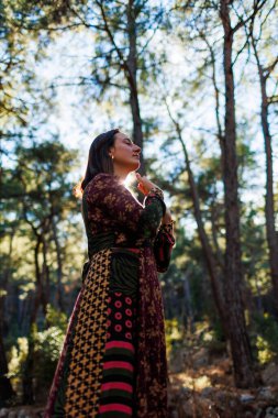 Genç ve güzel bir dansçının portresi. Doğa manzaraları arasında dikkatle pratik yapıyor. Genç ve güzel bir kız ormanda ağaçların arasında dans edip şarkı söylüyor. Kız doğayla baş başa..
