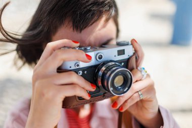 Güzel bir kadın dışarıda analog bir kamerayla fotoğraf çekiyor. seyahat ve tatil.