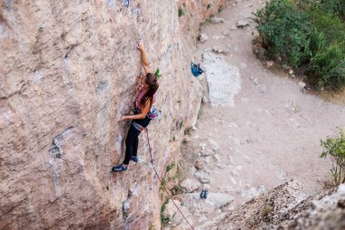 Kız rock tırmanıyor. Dağcı kayaya tırmanmak için eğitim alıyor. Güçlü bir atlet zor bir tırmanış rota üstesinden gelir. Aşırı hobi. Doğa sporları için bir kadın giriyor. Doğal kayalık arazi