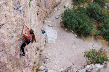 sport climbing. the girl overcomes the climbing route on the rock. sport and fitness.