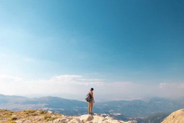 Gezgin, dağın tepesinde duruyor. Kız dağlara gidiyor. seyahat ve macera.