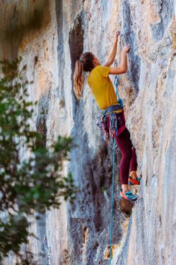 Climber zorlu tırmanma rotasını üstesinden geliyor. Bir kız kayaya tırmanıyor. Aşırı spor yapan kadın. Aşırı hobi
