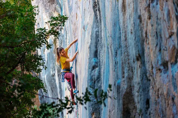 少女は岩に登った クライマーは自然地形で電車を運転している 最高のスポーツ アウトドア活動 女性は難しいルートロッククライミングを克服します ロイヤリティフリーのストック画像