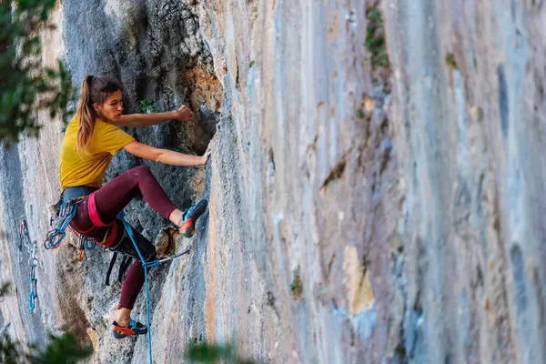 Eine Junge Und Starke Frau Klettert Auf Einem Felsen Kraft lizenzfreie Stockfotos