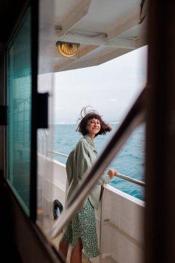 Kız bir yolcu gemisinin güvertesinde duruyor. Kız seyahat ediyor. Genç ve güzel bir esmer yat ile seyahat ediyor. seyahat ve macera.