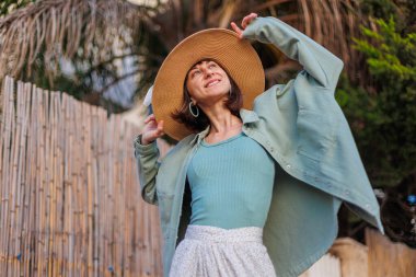 Şık yaz kıyafetleri içinde güzel bir esmerin portresi. Tatil sırasında sokakta gülümseyen neşeli genç bir kadın. Mutlu kız..