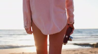 Kameralı kız. Yaz havası. Elinde kamera olan bir kadın kumsalda yürüyor. Arkadan bak. macera tatili. Yaz tatili.