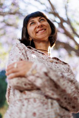 Çekici ve neşeli bir kadın iyi bir günde özgür ve neşeli hisseder. Parkta yürü.