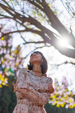 Şık bir yaz elbisesi içinde gülümseyen güzel bir kadının portresi. Sokakta poz veren kaygısız bir kadın. Pozitif model yürüyüş yaparken eğleniyor. Neşeli ve mutlu.