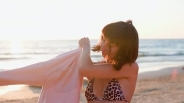 Yaz havası. Sahildeki kız. Kaplan mayosu giymiş genç bir kız kumsalda dinleniyor. Moda & Biçimi. Seyahat, turizm konsepti.