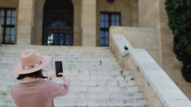 Telefonu olan bir kız. Genç bir kadın, eski kasabayı gezerken telefonuyla güzel bir evin fotoğrafını çekiyor. Genç, çekici, gülümseyen kadın turist yeni bir şehri keşfediyor..