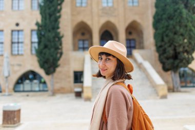 Şapkalı bir kadının portresi. Turistik yerlere seyahat ediyorum. Kameraya gülümseyen şapkalı şık bir kızın fotoğrafı. tarihsel yerler.