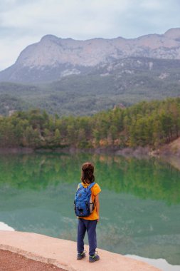 Yaz kampı. Sırt çantalı bir çocuk güzel bir dağ gölüne bakıyor. Sakin, huzurlu, düşünceli, mutlu ve özgür bir çocuk bir dağ gölünde. Çocuklarla Tatil