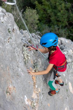 Dağcı çocuk. Çocuk kaya tırmanışı eğitimi alıyor. Doğada spor.