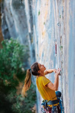 Climber zorlu tırmanma rotasını üstesinden geliyor. Bir kız kayaya tırmanıyor. Aşırı spor yapan kadın. Aşırı hobi