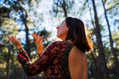 Ormanda eli havada dans eden genç ve güzel bir kadın. Denge, uyum ve sağlık kavramı.