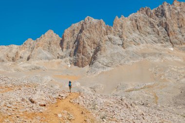 Yaz kampı. Sırt çantalı çocuk. Çocuk sırt çantasıyla dağlarda geziyor. Yüksek dağlarda yaz yürüyüşü. Bir çocuk dağ yolunda yürüyor. Türkiye.