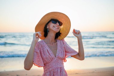 Genç bir kadın sahilde duruyor ve tatilinin tadını çıkarıyor. Genç bir kızın portresi.