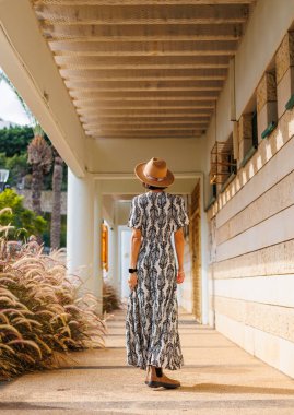 Sokakta yürüyen güzel bir esmerin uzun boylu portresi. Arkadan bak. Yazın açık havada. moda ve tarz kavramı.