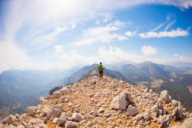Dağlardaki kız. Dağcı kayalık tepe boyunca gider. Dağlara tırmanan bir kız. Macera konsepti ve dağlarda yürüyüş.. 