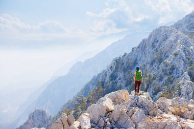 Dağlardaki kız. Bir dağcı kayalık bir tepe boyunca yürür. Kız dağlara tırmanıyor. Dağcılık ve kaya tırmanışı. Macera konsepti ve dağlarda yürüyüş.