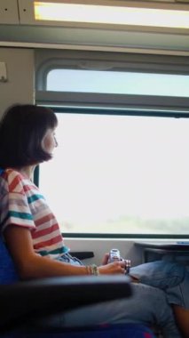 Genç bir kız trenle seyahat ederken pencereden güzel bir manzaranın fotoğrafını çekmek için bir kamera kullanır. Çekici bir kız demiryolu ile seyahat eder. film kamerası