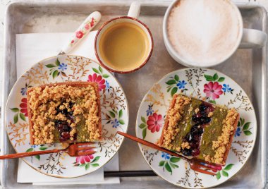 İki kişilik tatlı ve kahve. Fıstıklı fındıklı kek ve açık hava kafedeki masada kahve. Kek ve kahve.