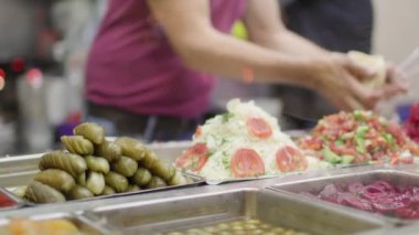 İsrail 'de sokak yemeği. Pita ve falafel. Adam falafel ve sebzeli pide hazırlıyor..
