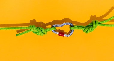 two ropes with secure knots are connected by a carabiner. Equipment for rock climbing and mountaineering. reliable connection. Safety rope. concept of reliability and strength.