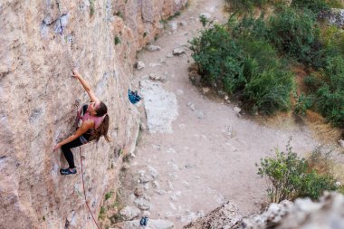 Kız rock tırmanıyor. Dağcı kayaya tırmanmak için eğitim alıyor. Güçlü bir atlet zor bir tırmanış rota üstesinden gelir. Aşırı hobi. Doğa sporları için bir kadın giriyor. Doğal kayalık arazi