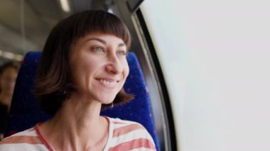 Tren yolculuğu. Genç bir kadın, elinde kamerayla tren yolculuğunun tadını çıkarıyor. Turist kamerada güzel turistik yerlerin fotoğraflarını çeker. Film kamerası. Kız film kamerası kullanıyor..