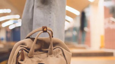 Çantası olan kız tren istasyonunda bekliyor. Moda çantaları yakın plan. Treni bekle. Metrodaki kız. Şık giyinmiş genç bir kız ve metroda çantası var. moda ve tarz.