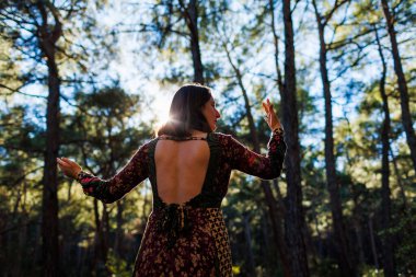 Genç ve güzel bir dansçının portresi. Doğa manzaraları arasında dikkatle pratik yapıyor. Genç ve güzel bir kız ormanda ağaçların arasında dans edip şarkı söylüyor. Kız doğayla baş başa..