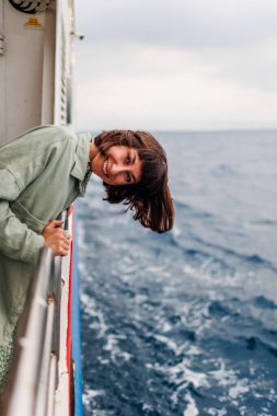 Bir yolcu gemisinde tatil. Rahat, modaya uygun bir kadının yolcu gemisinde gezintisinin keyfini çıkarırken yan görüntüsü. Genç bir kız yatla seyahat ediyor. seyahat ve macera.